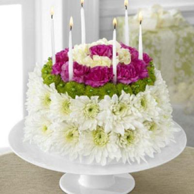 The Wonderful Wishes Floral Cake is set to celebrate their birthday with sweet sentiments blooming with chrysanthemums and carnations. Perfectly arranged in the shape and styling of a colorful birthday cake are white chrysanthemums, green button poms, pale yellow carnations and magenta mini carnations. Presented on a white cake plate, this memorable flower arrangement will add to the festivities of their special day.